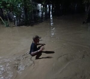 Kondisi memprihatinkan saat seorang warga berjalan menembus air banjir setinggi dada di salah satu titik di Kabupaten Pidie Jaya, Rabu malam. Air yang keruh dan deras menyulitkan pergerakan warga yang berusaha menyelamatkan diri dan harta benda. Foto:
